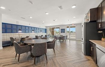 A dining room and kitchen area with a table and chairs
